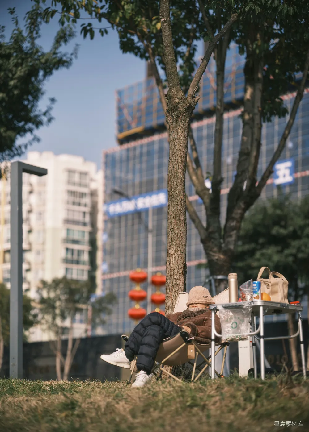 高清摄影  在树下享受野餐的人。