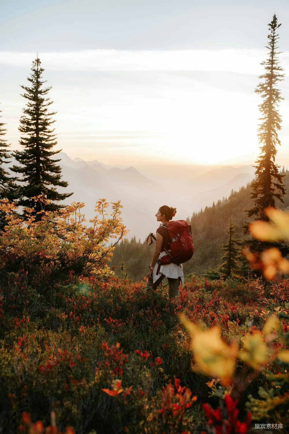 高清摄影  背着背包的女人在日落时分在山上徒步旅行