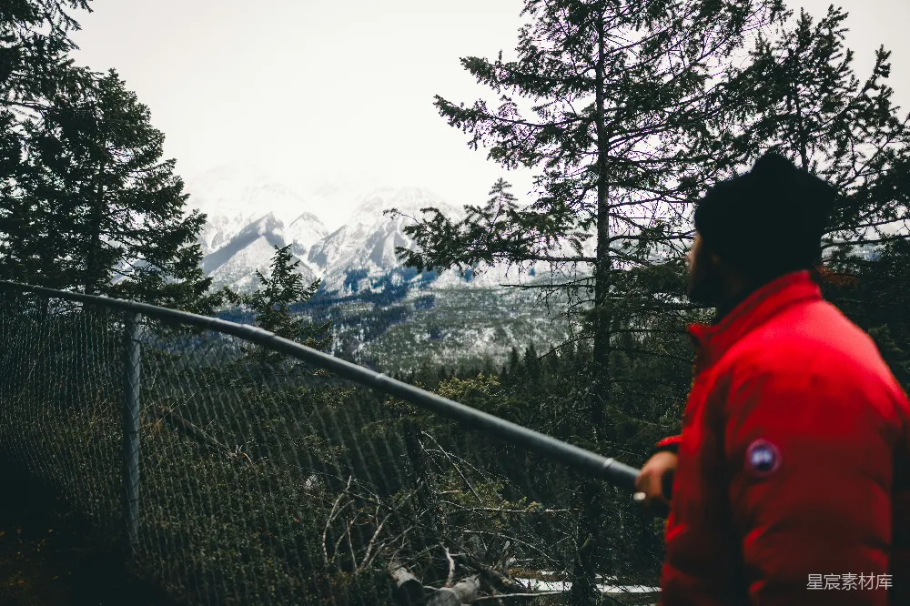 高清摄影  男人在远处眺望着一片雪山。