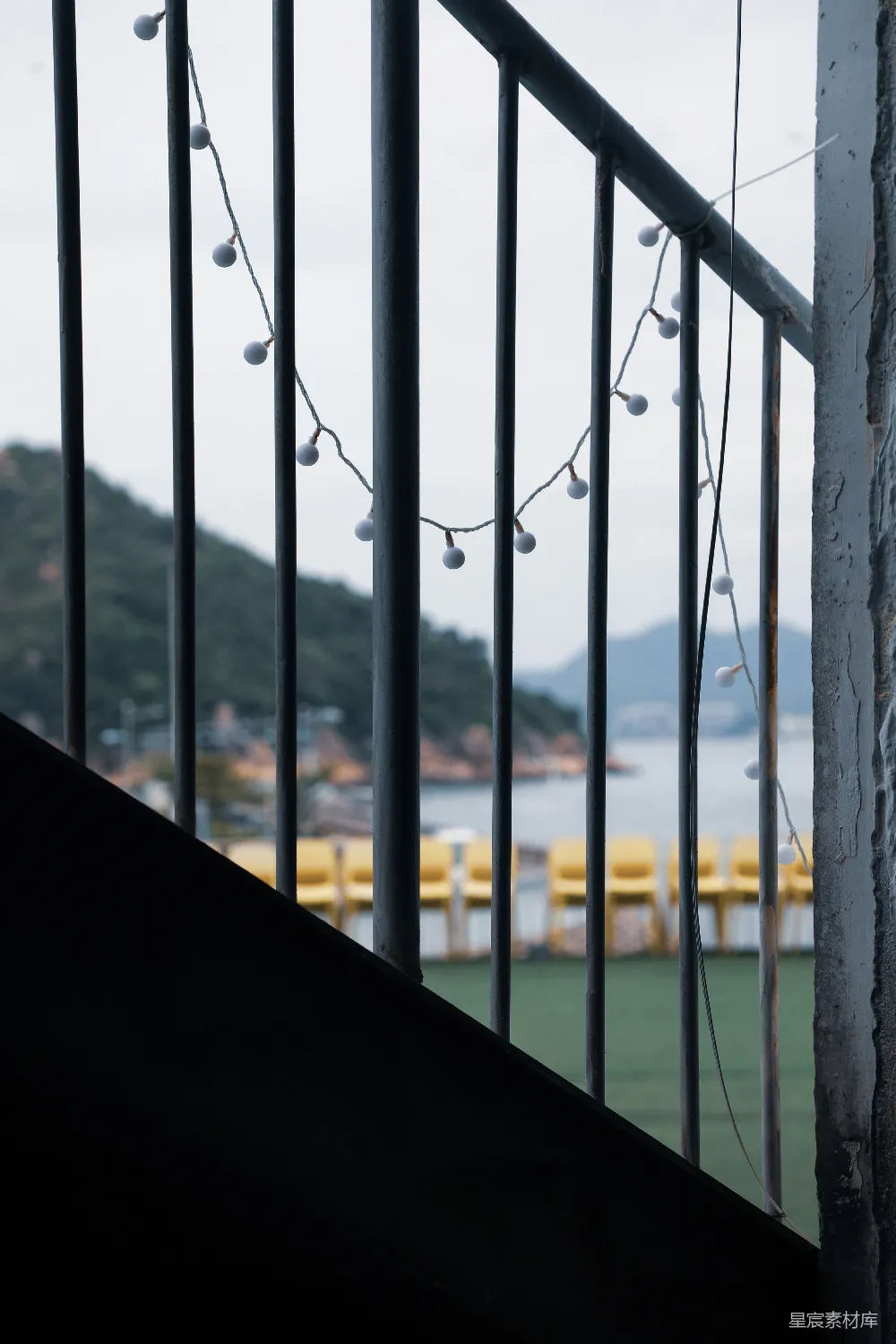 高清摄影  悬挂的彩灯垂在栏杆上，视野开阔，能看到海景。