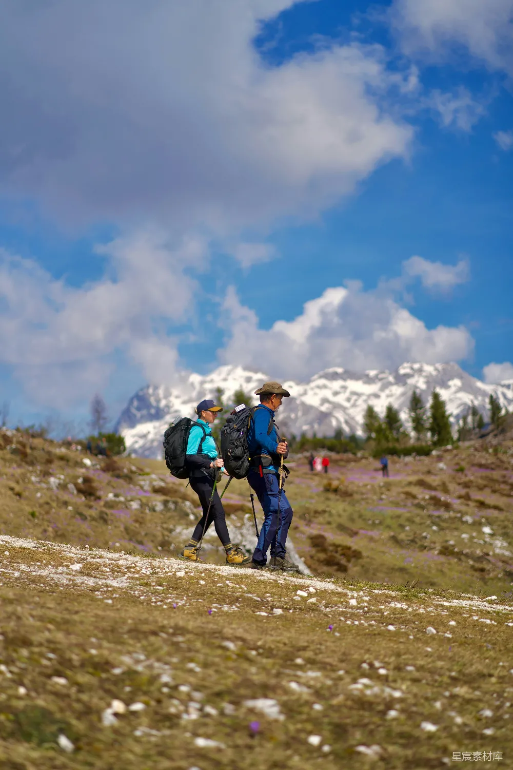 高清摄影  带着背包的两名徒步旅行者沿着山间小路攀登