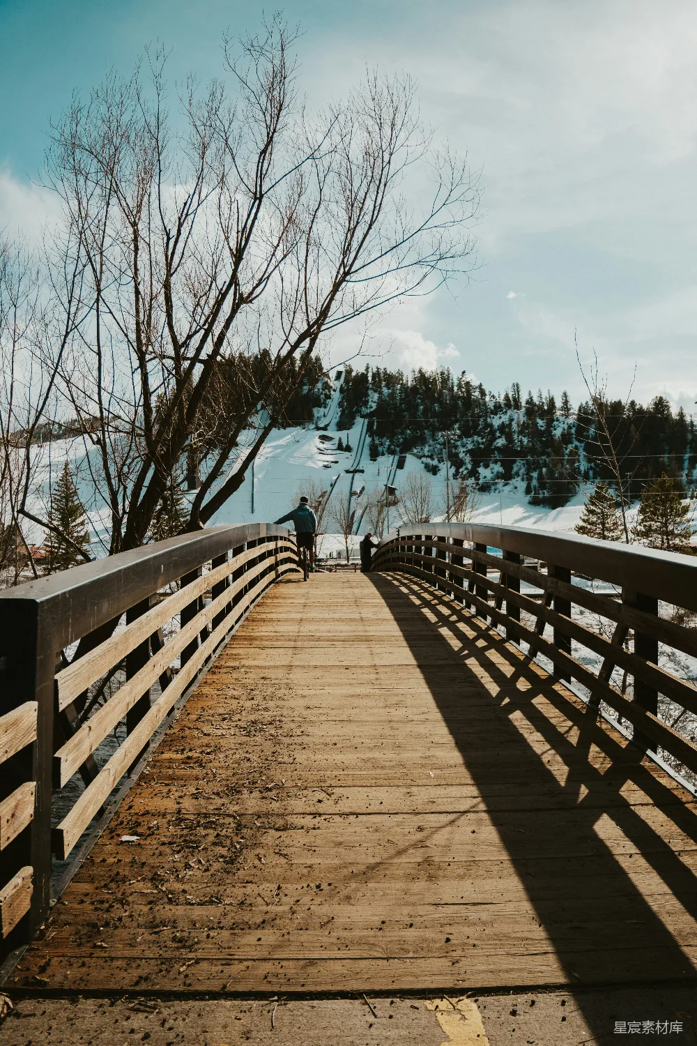 高清摄影  一个人走在一座桥上，朝着雪景走去。