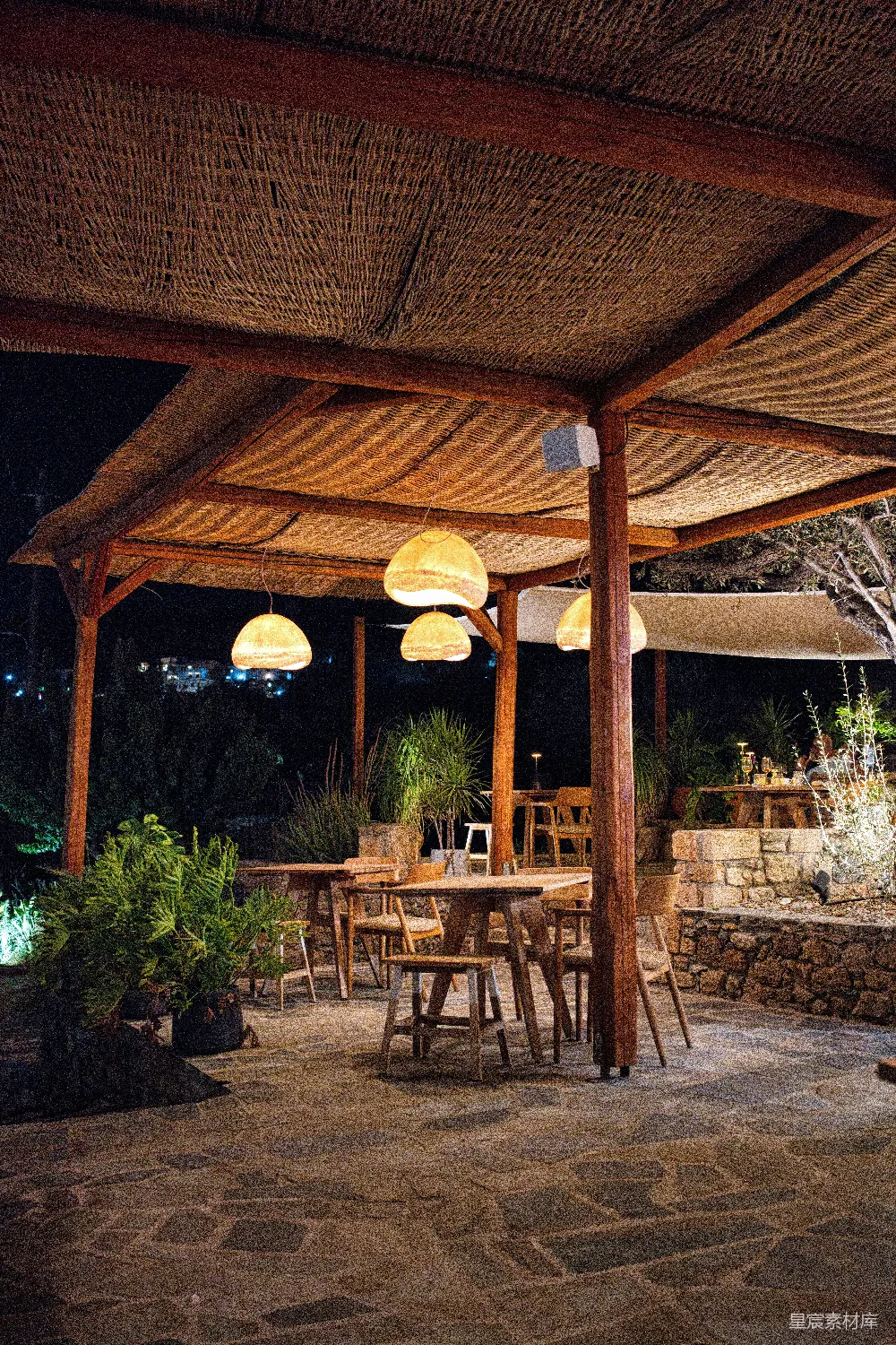 高清摄影  户外用餐区，夜间有木质桌椅。