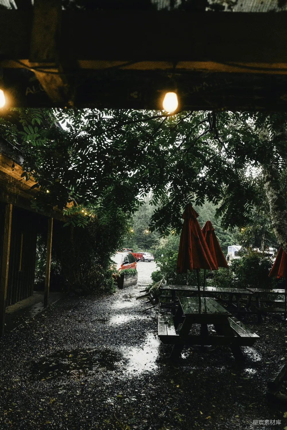 高清摄影  雨天里，红色雨伞下的野餐桌