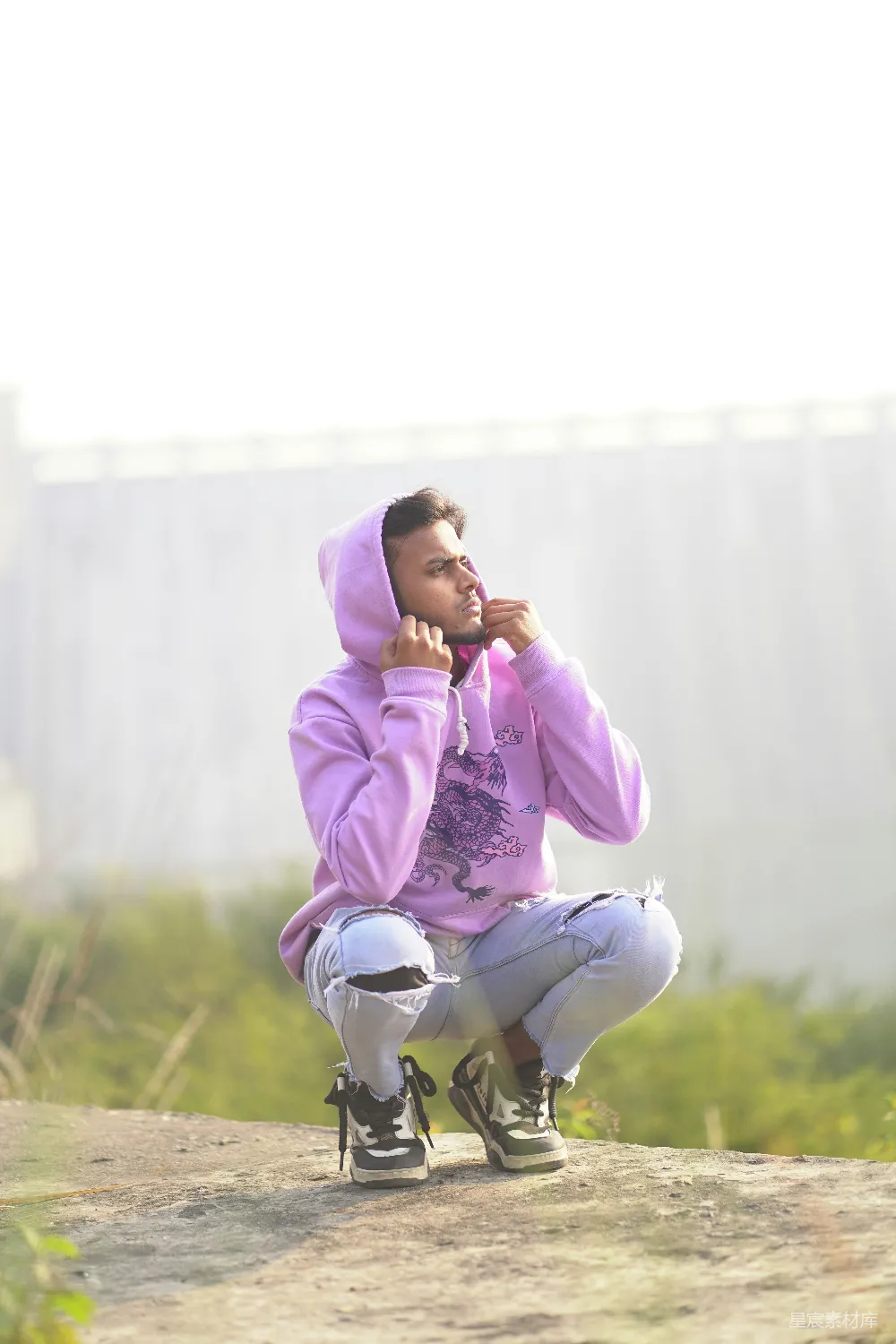 高清摄影  一个穿着紫色连帽衫的男人坐在滑板上