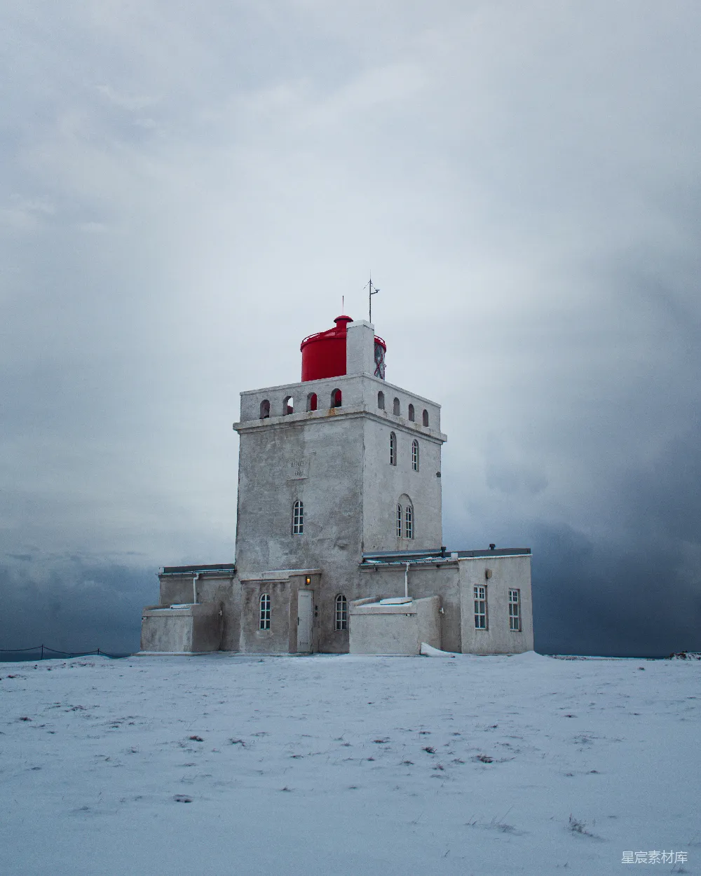 高清摄影  白色和棕色的混凝土建筑矗立在积雪覆盖的地面上。