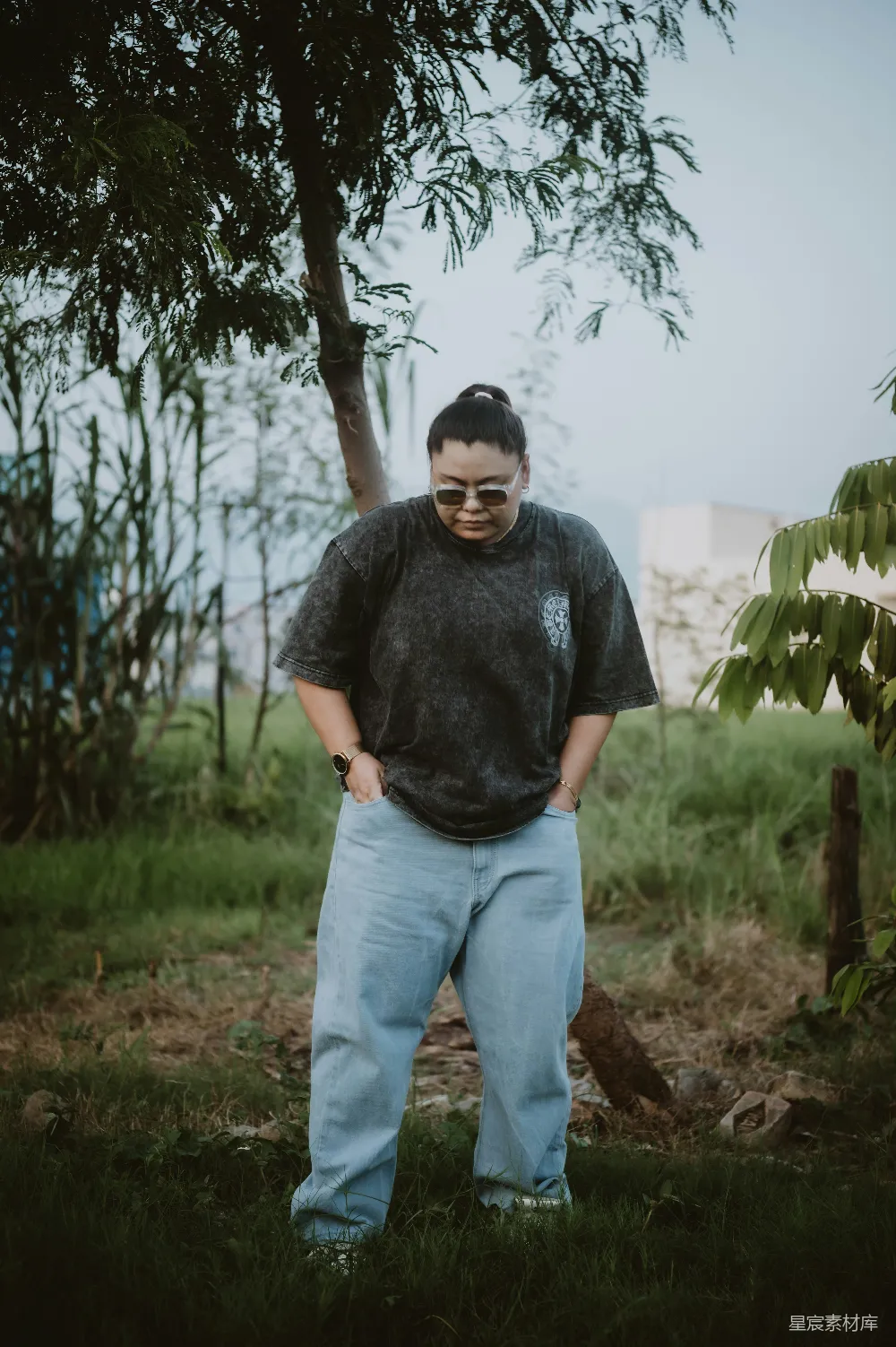高清摄影  一个男人站在草地上，双手叉腰。