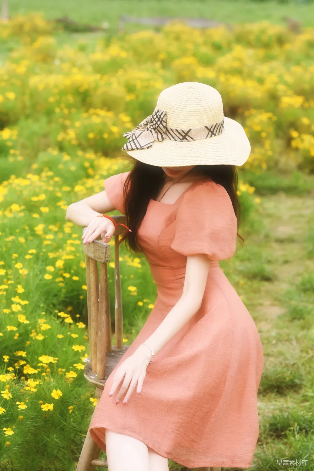 高清摄影  戴着帽子的女人靠在一个田里的柱子上。