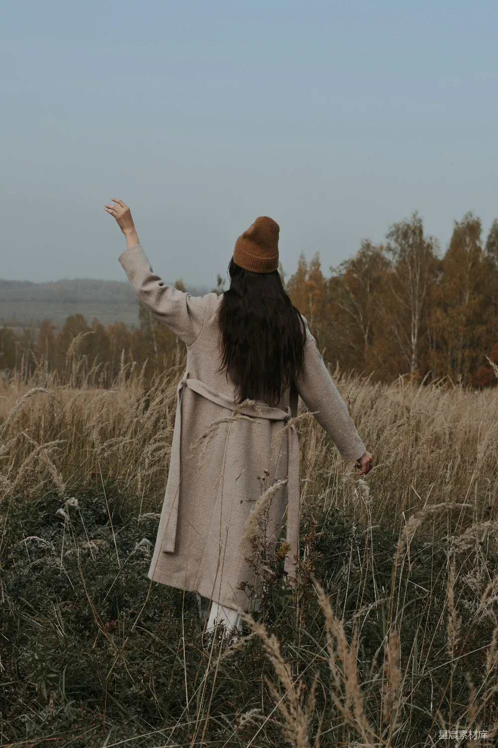 高清摄影  一个女人站在一片高高的草地上。