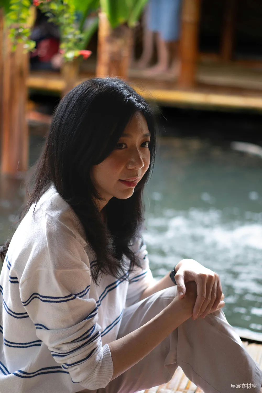 高清摄影 人物 一位女士坐在水边的地上。