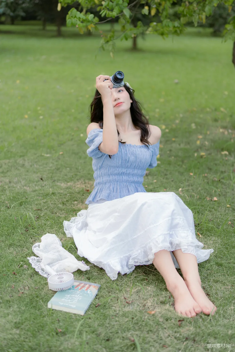 高清摄影  一个穿着蓝色连衣裙的女人坐在草地上