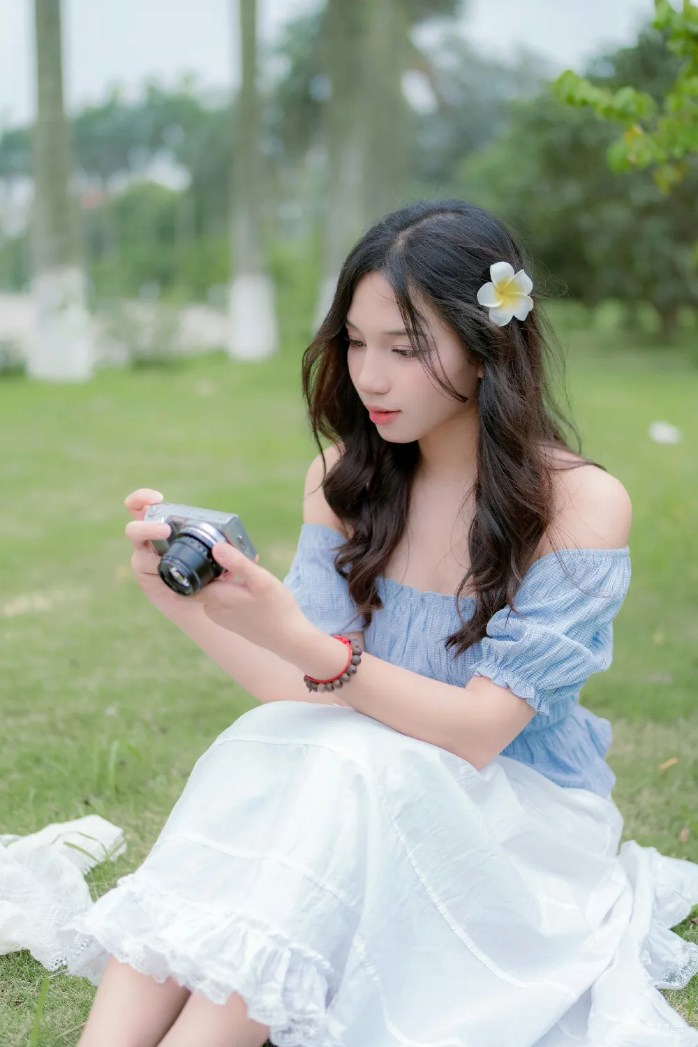 高清摄影  一个女人坐在地上拿着相机。