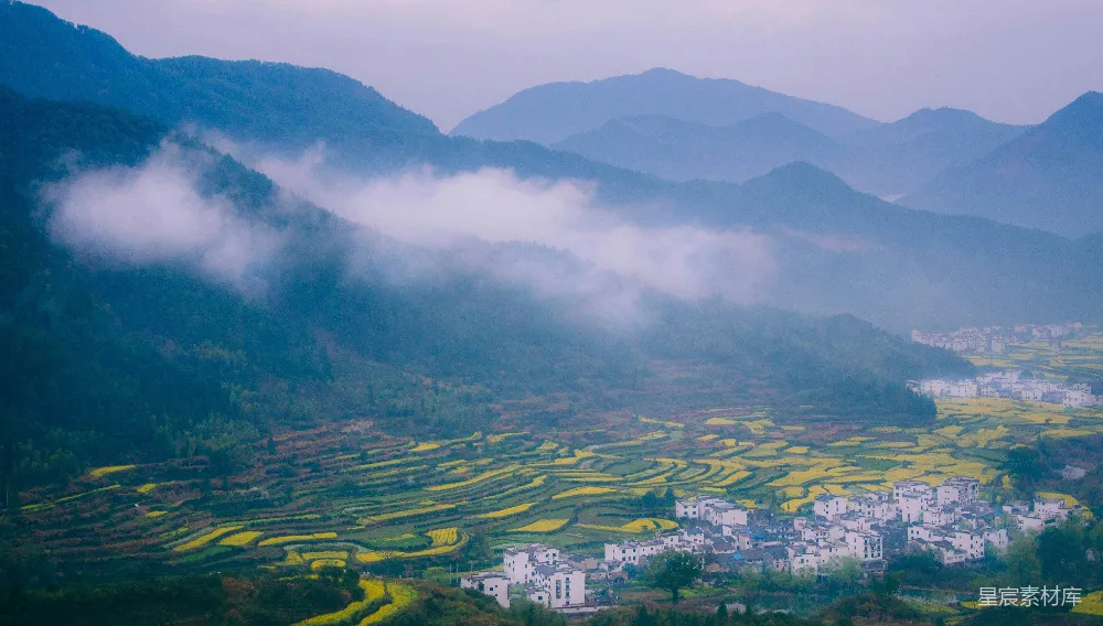 高清摄影  白天拍摄绿地附近的房屋和建筑的航拍照片，可以看到远处的山脉。