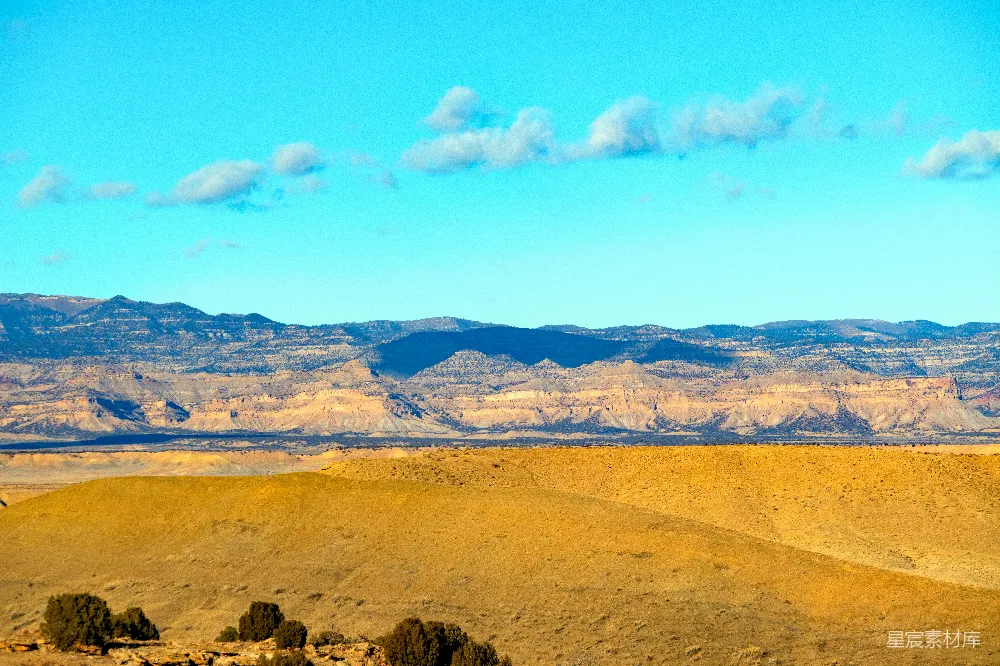 高清摄影  一片沙漠景色，背景中有山脉。