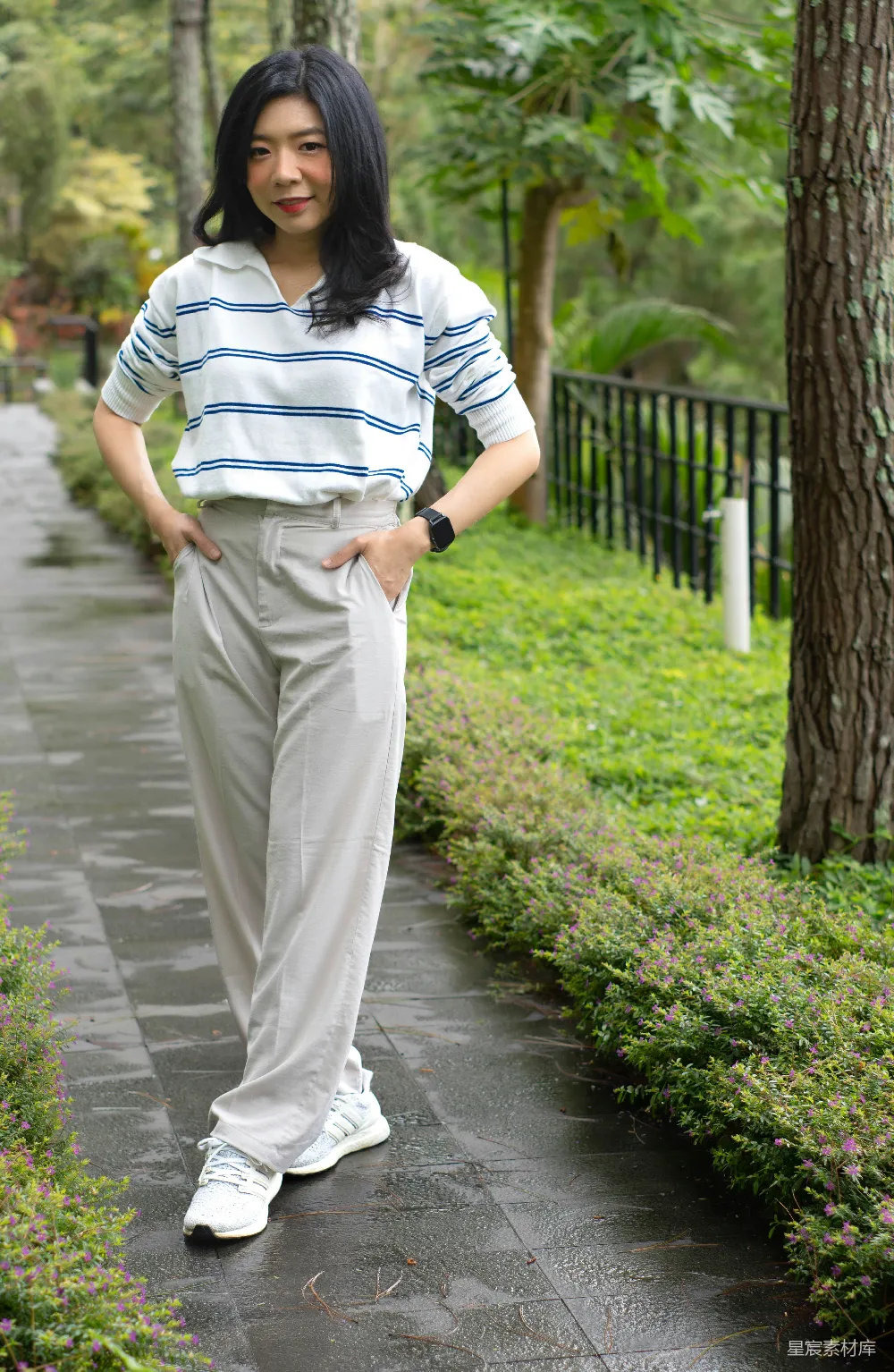 高清摄影  一个女人站在公园的小路上。