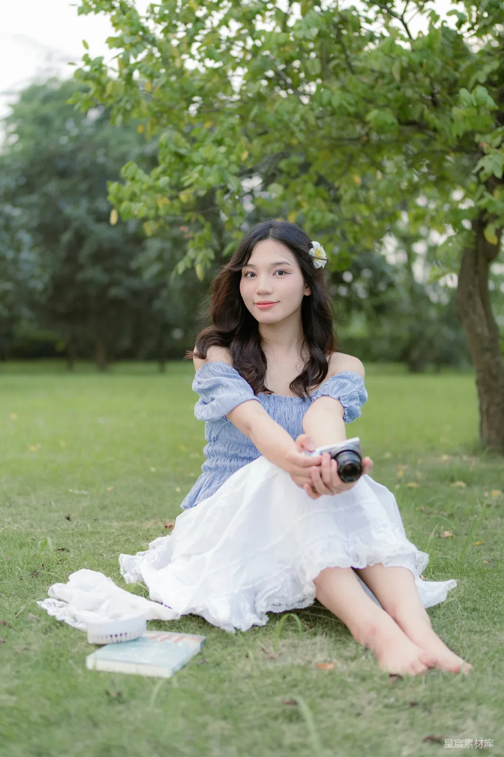 高清摄影  一位女士坐在草地上，手里拿着一瓶酒。