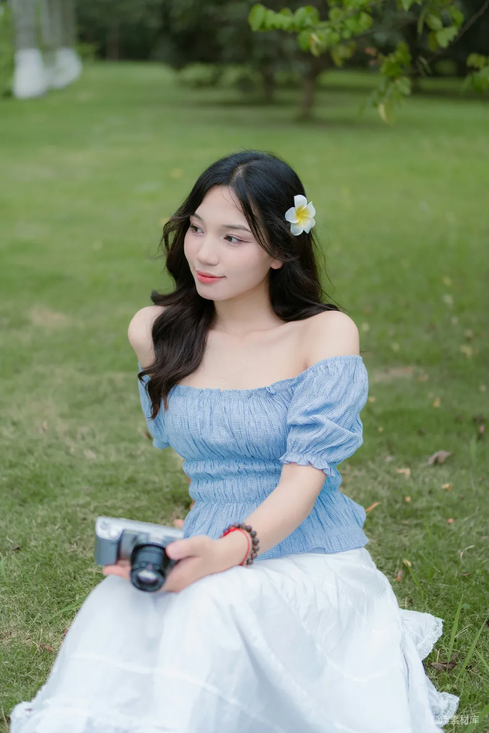 高清摄影  一个穿着蓝色连衣裙的女人拿着相机。