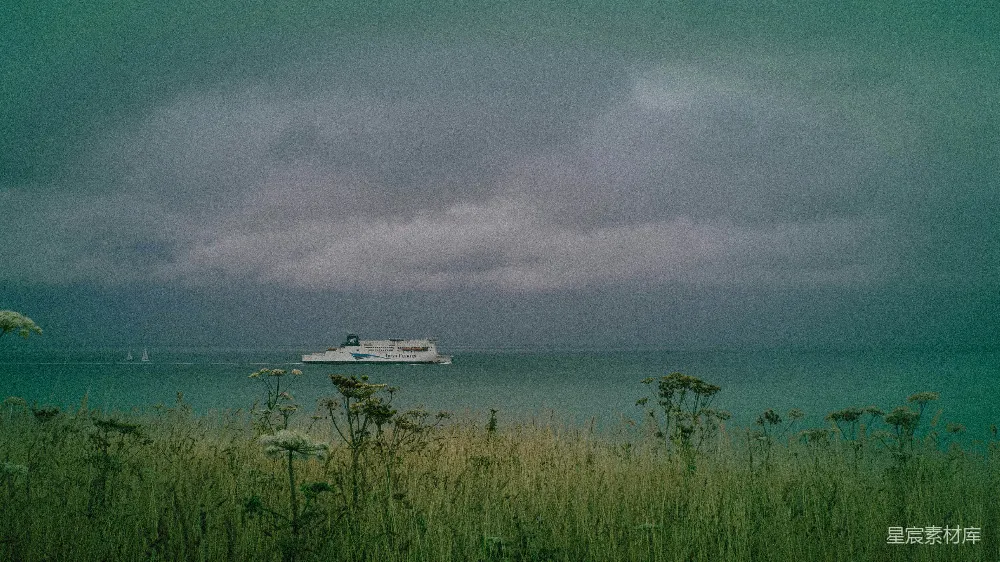 高清摄影  一艘渡轮在暴风雨的天空下航行穿过海洋。