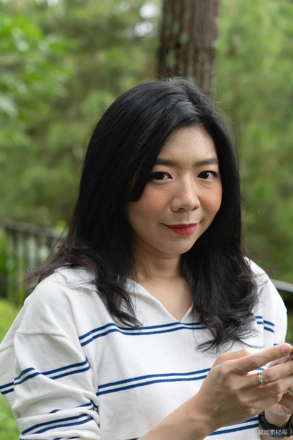 高清摄影 人物 一位女士手里拿着一部智能手机。