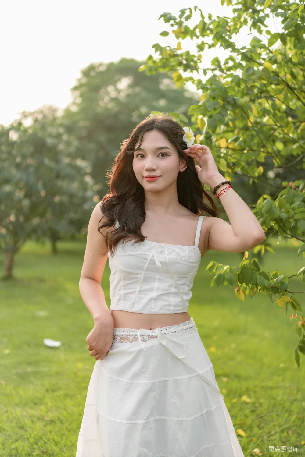 高清摄影  一位穿着白色连衣裙的女士正在摆姿势拍照。