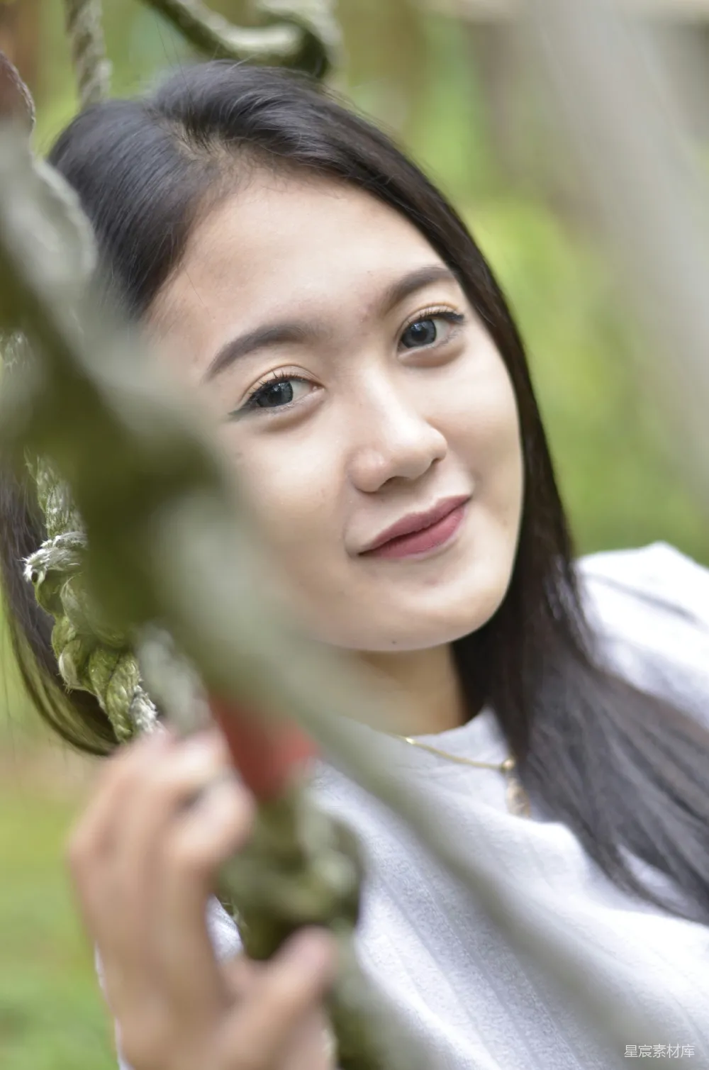 高清摄影  一个女人一边抱着植物，一边微笑着。