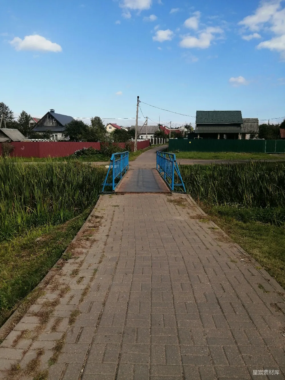 高清摄影  一条铺着砖块的小路通往一片草地。