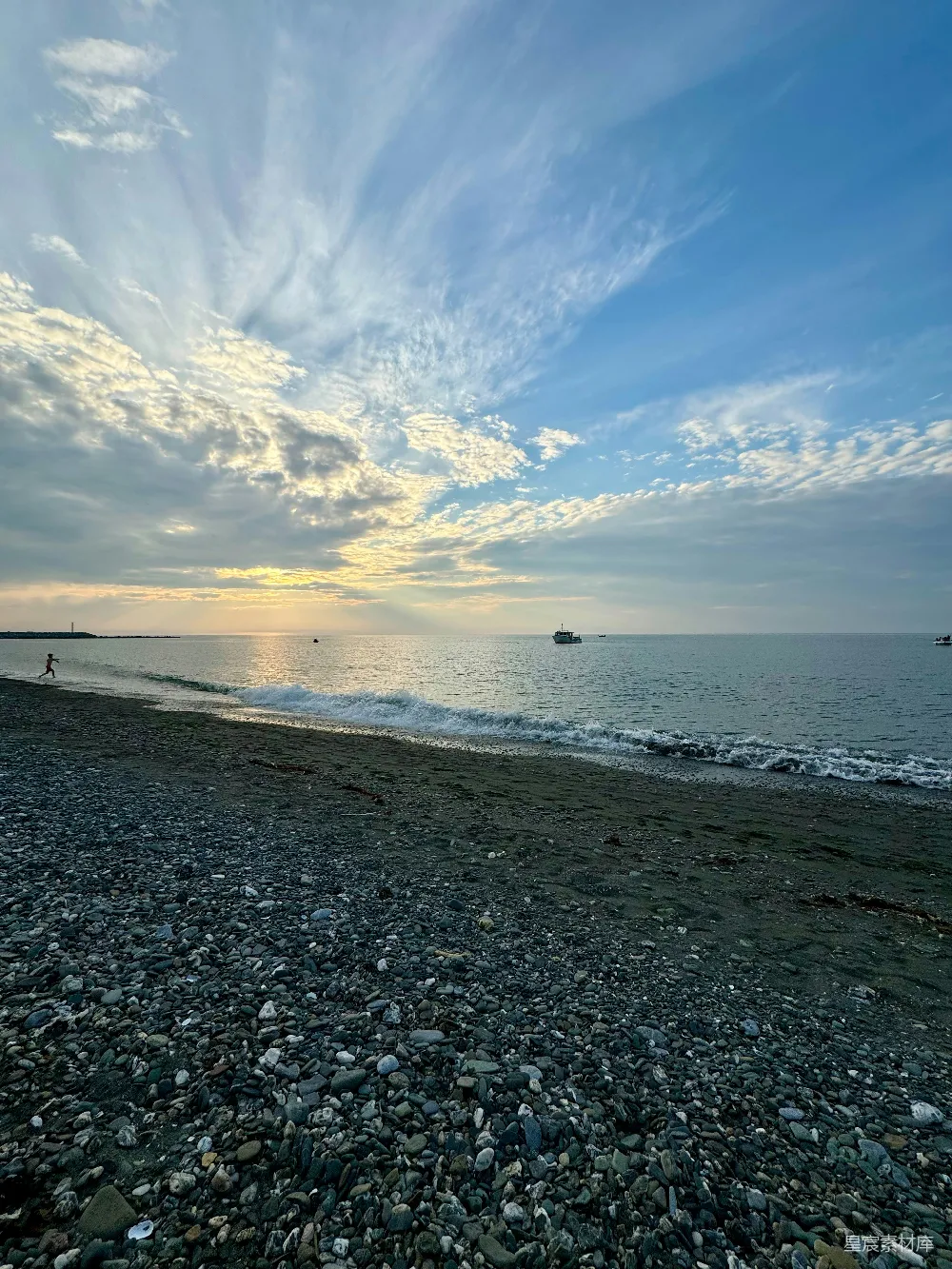 高清摄影  一条岩石和水相间的海滩，在多云的天空下。
