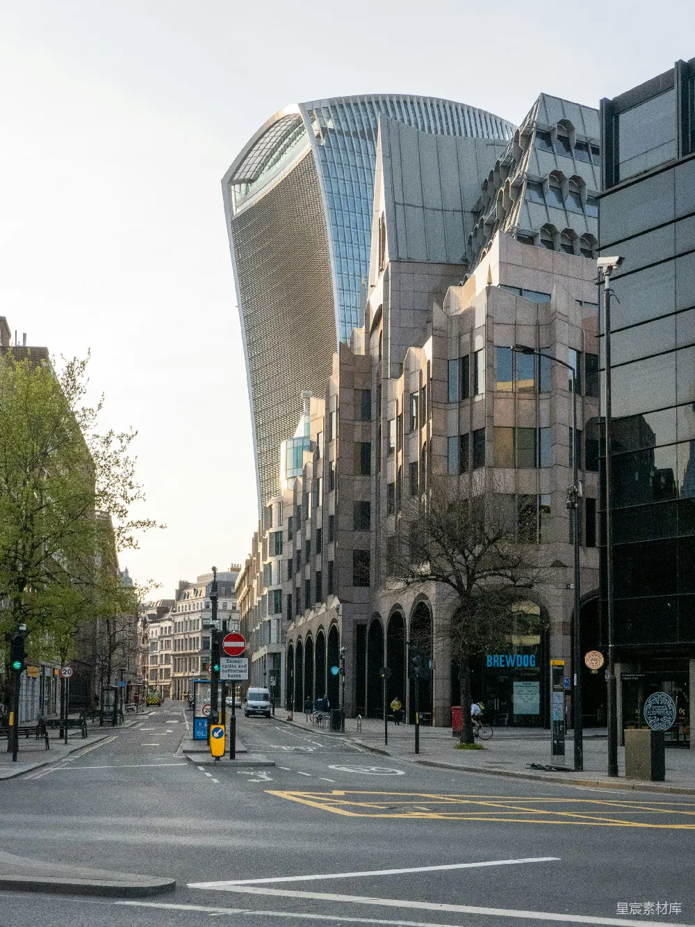 高清摄影  一条城市街道，两旁是高大的建筑物，街道上有一个交通信号灯。