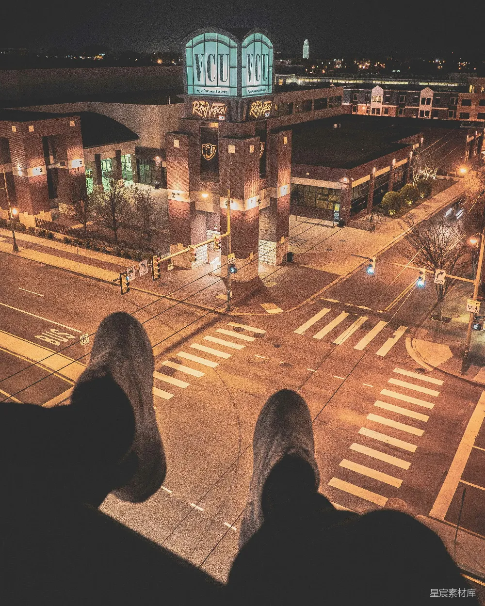 高清摄影  一个人坐在楼顶，俯瞰着灯火通明的街道。