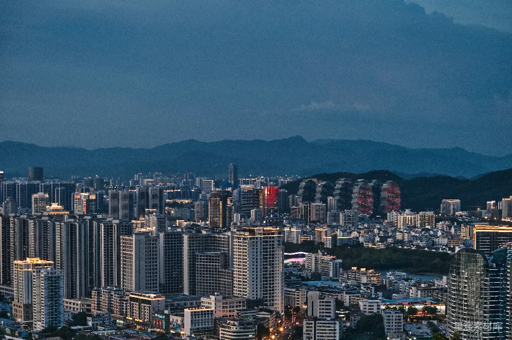 高清摄影  一个大城市，背景是高楼和山脉。