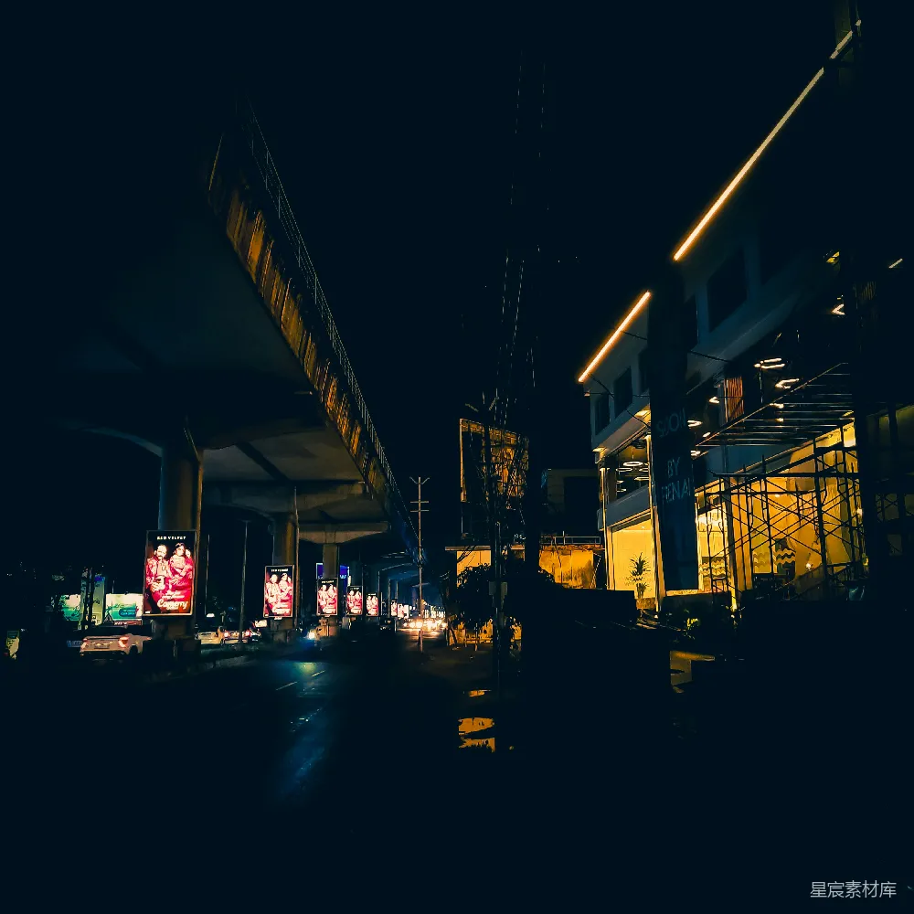 高清摄影  一条夜晚的城市街道，背景中有一座桥。