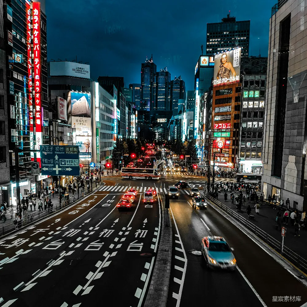 高清摄影  夜晚高楼之间的道路上行驶的汽车
