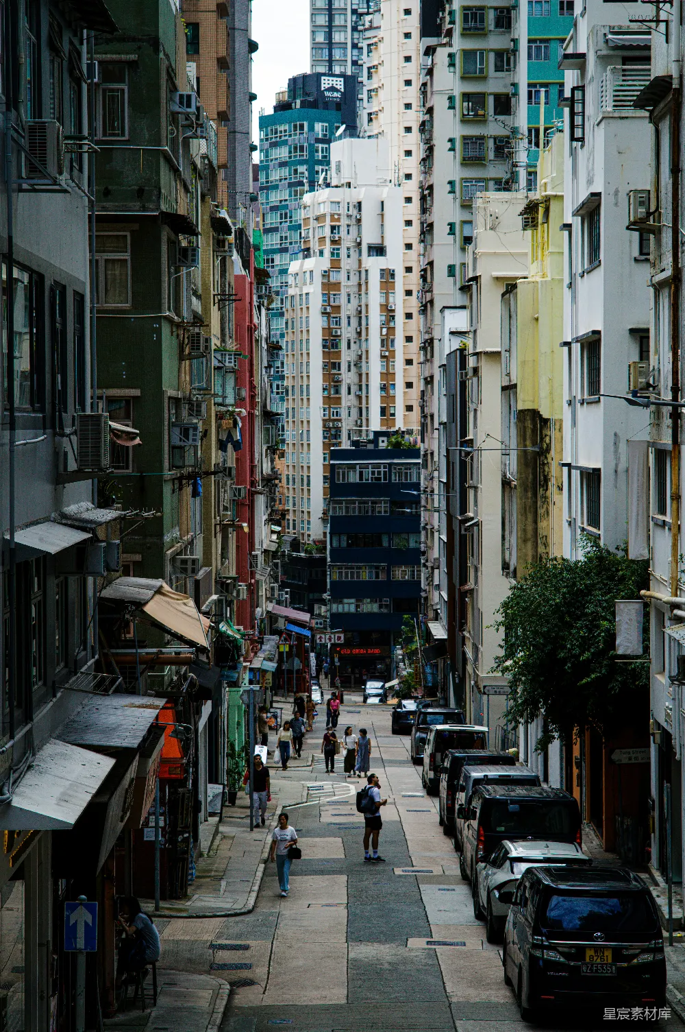 高清摄影 人物 狭窄的街道两旁是高楼大厦，行人来往。