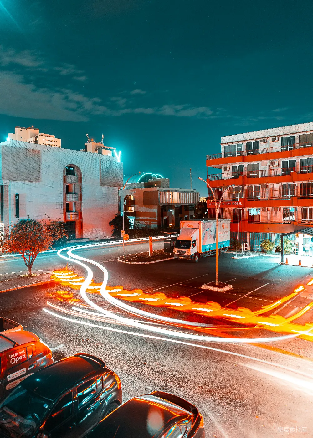 高清摄影  夜晚，棕色混凝土建筑附近的马路上有几辆汽车。