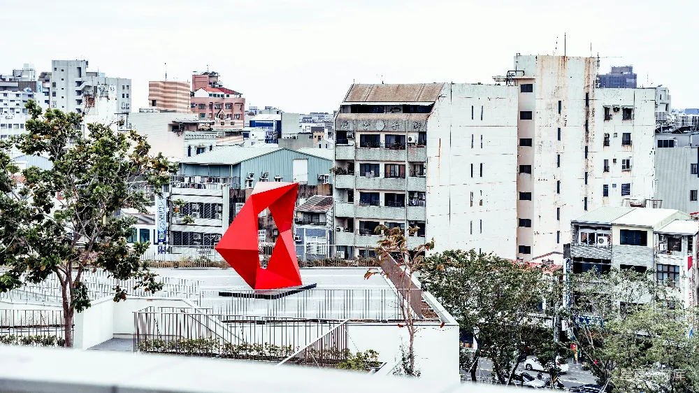 高清摄影  白天，白色金属栅栏旁的白色混凝土建筑旁挂着一面红白相间的旗帜。