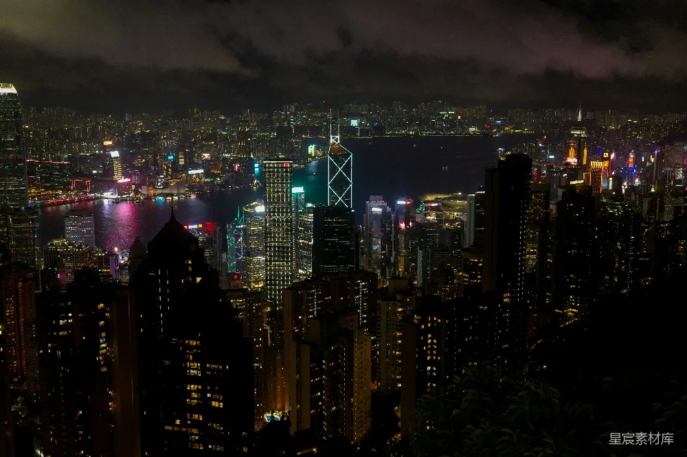 高清摄影  夜色中的繁华城市景观，灯火辉煌的摩天大楼和远处的水体。