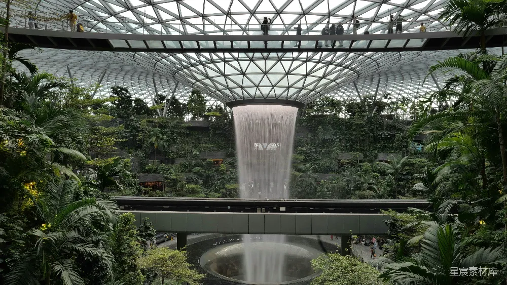 高清摄影  室内的瀑布，周围绿意盎然，搭配现代化的建筑结构。