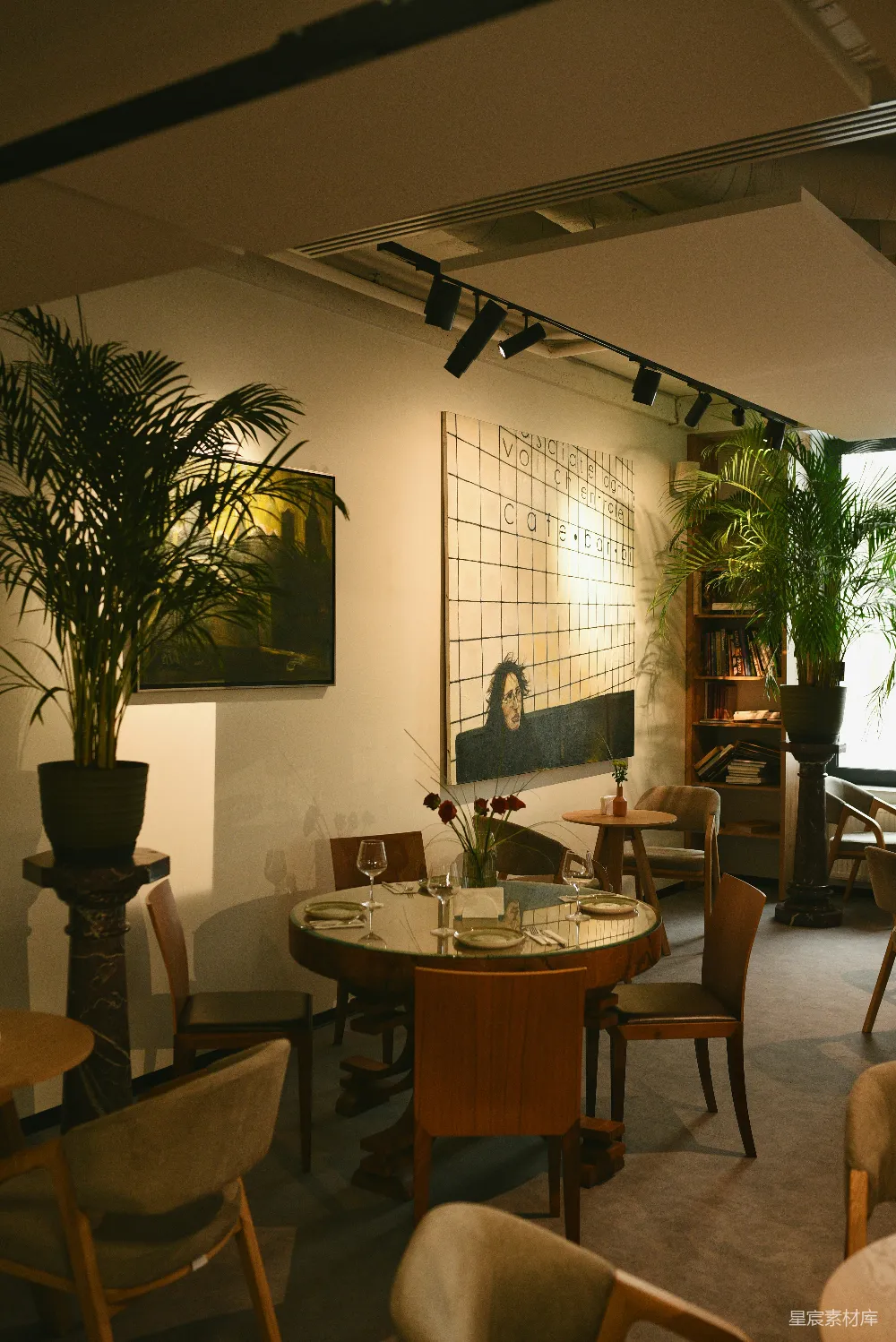 高清摄影  一家优雅的餐厅内饰，配有餐桌、盆栽植物和艺术品。