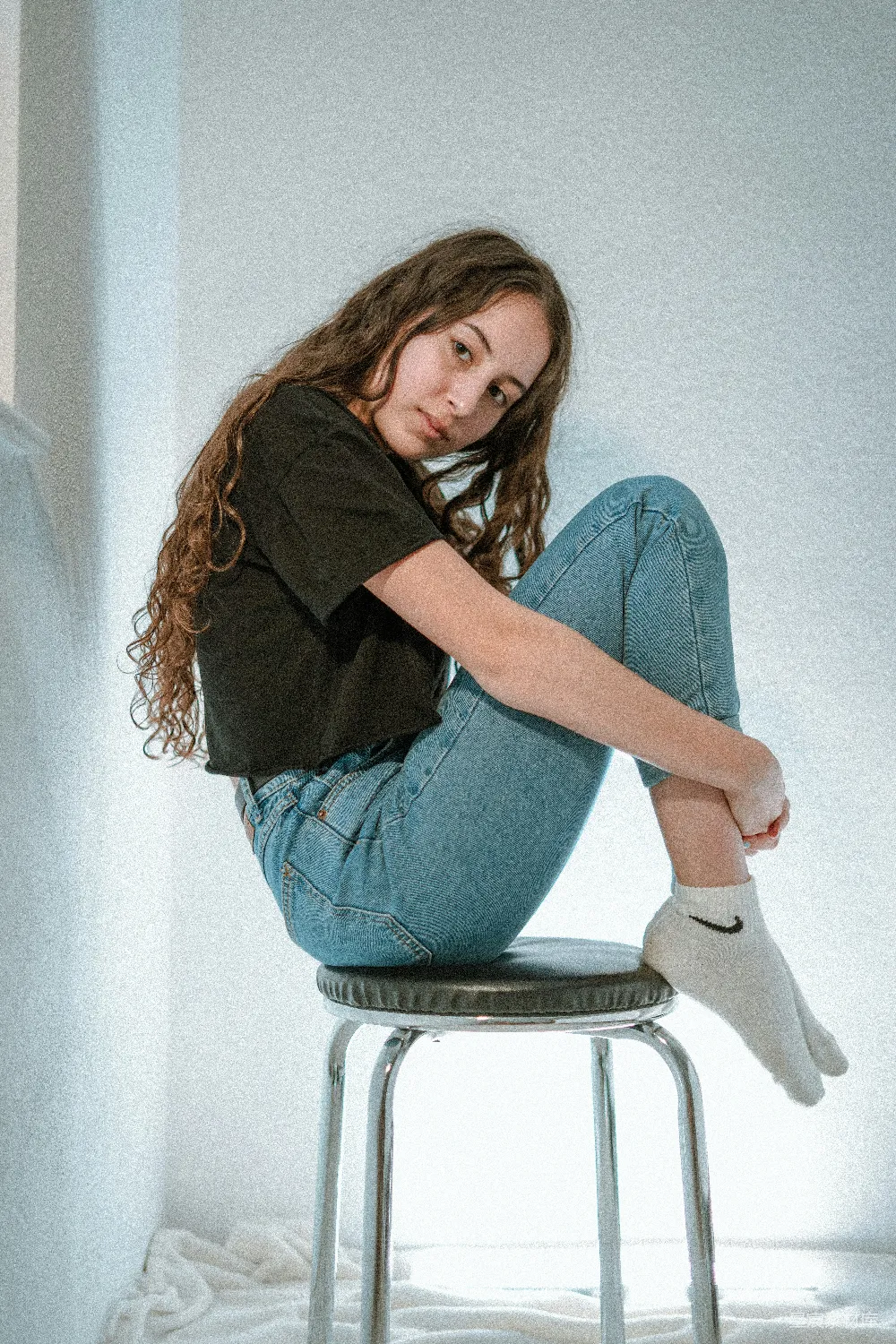 高清摄影  穿黑色长袖衬衫和蓝色牛仔裤的女人坐在白色的椅子上。