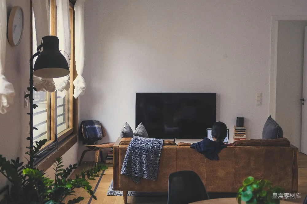 高清摄影  坐在LED电视机前的沙发上的人