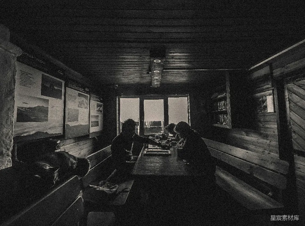 高清摄影  人们坐在一间质朴小屋的餐桌旁。