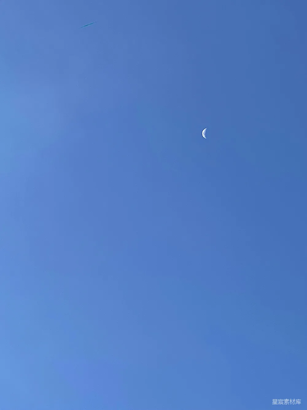 高清摄影  湛蓝的天空中有一轮半圆的月亮。