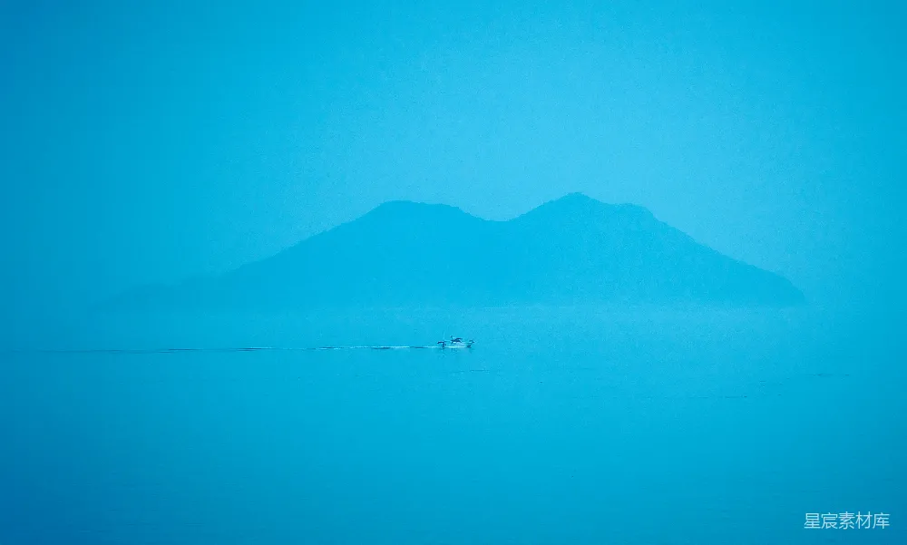 高清摄影 壁纸 一座山的剪影映在蓝色的水面上。