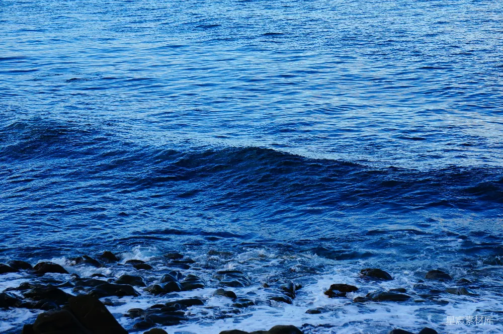 高清摄影  深蓝色的海浪拍打着岩石岸。