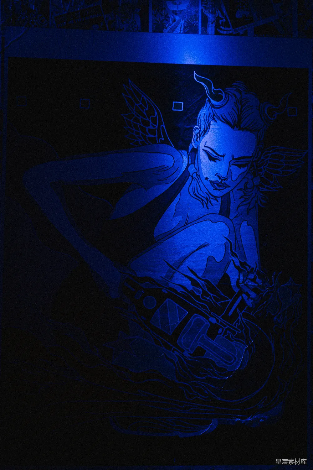 高清摄影  一幅蓝光照射的画，画中是一位有翅膀的戴角的女性。