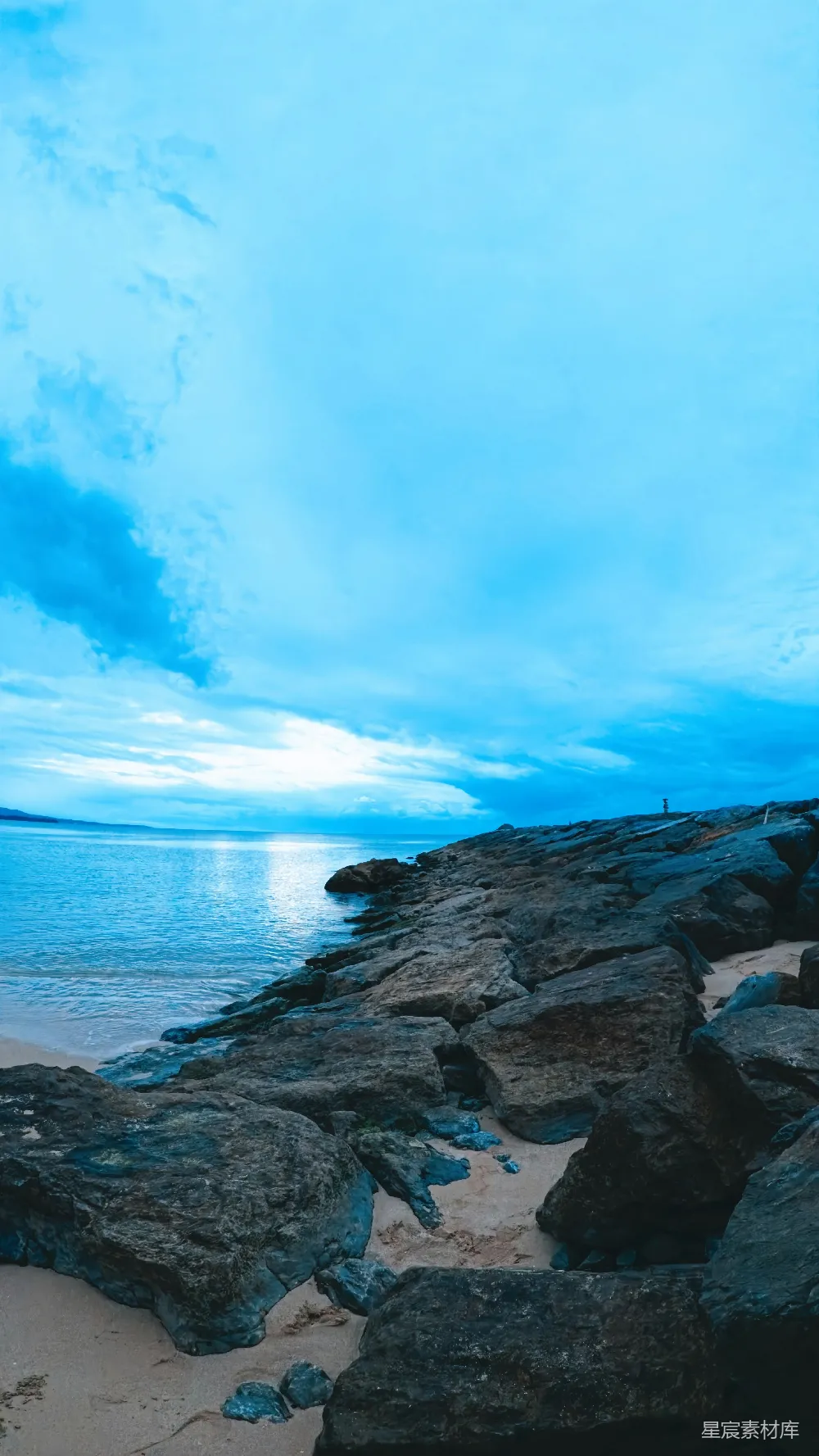 高清摄影  岩石海岸线，平静的海洋在阴云密布的天空下。