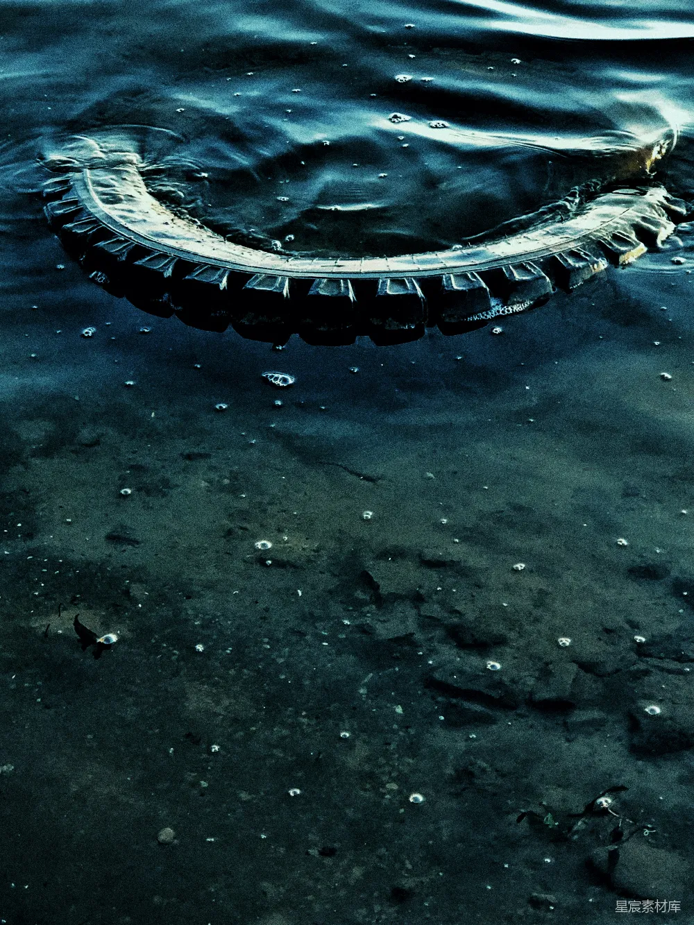 高清摄影  漂浮在水体中的一条轮胎