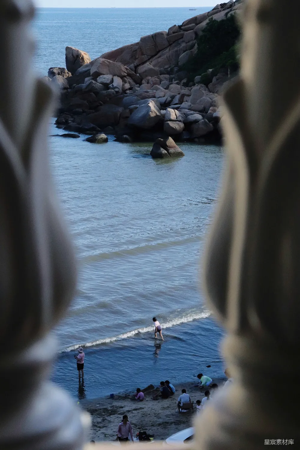 高清摄影  人们在海浪和大岩石旁享受海滩。