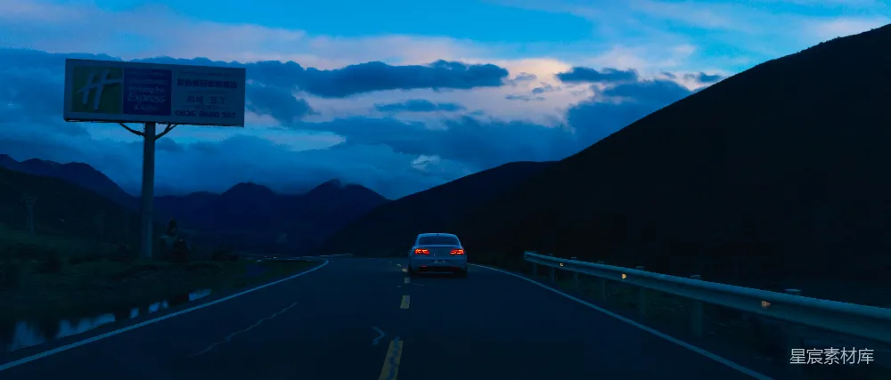 高清摄影  一辆车在道路上行驶，背景是山脉。