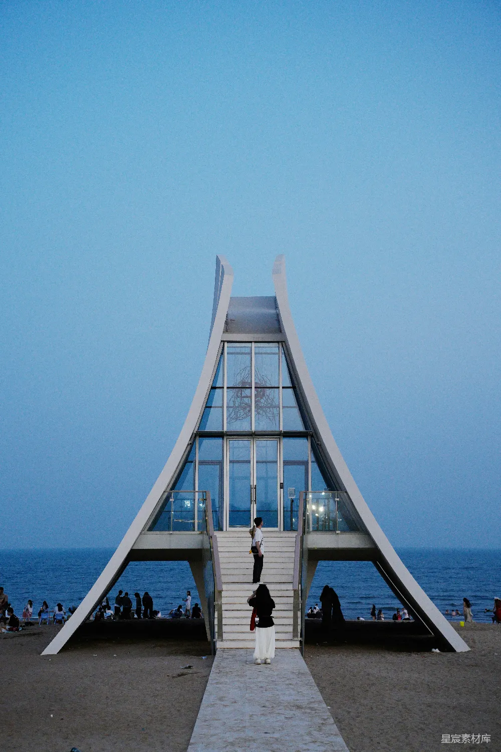 高清摄影  现代建筑结构在海滩上，人们在其中。